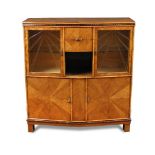 A good Art Deco glass fronted walnut cabinet, the chevron shaped front with coromandel beading,