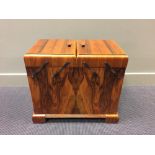 An Art Deco walnut work box, with twin hinged cantilever top with cupboard doors below raised on