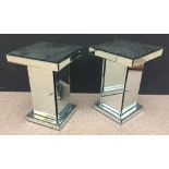 A pair of contemporary mirrored bedside tables, the square tops on column supports with cupboards
