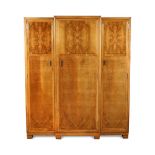 A Heal's Art Deco walnut triple wardrobe, the panelled doors with chrome handles opening to reveal a