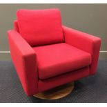 A contemporary Danish Swivel armchair by Bolia, the red upholstered cube shaped chair on a plywood