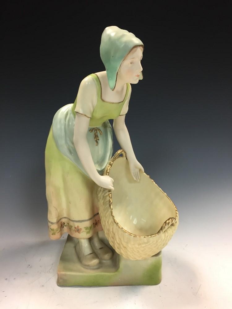 Ernst Wahliss, Vienna, an Austrian pottery figure of a young woman carrying a basket, circa 1900, - Image 2 of 5