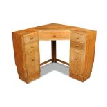A Heal's limed oak corner desk, with central drawer flanked by two further drawers and a cupboard to