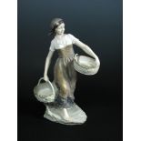 Doebrich for Ernst Wahliss, Vienna, an Austrian pottery figure of a young woman carrying baskets,