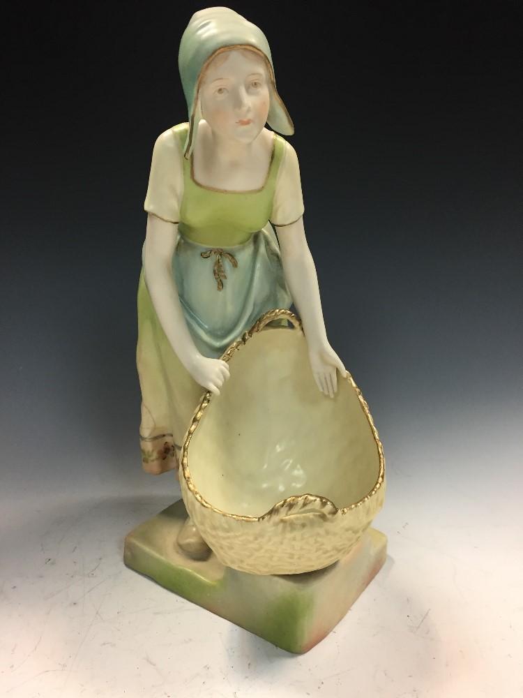 Ernst Wahliss, Vienna, an Austrian pottery figure of a young woman carrying a basket, circa 1900,