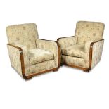 A pair of Art Deco walnut framed armchairs, the arms with carved detailing, raised on gadrooned feet