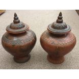 A pair of Moorish style terracotta urns and covers, each with applied and cut geometric