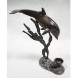 A bronze candle holder cast as a dolphin, modelled diving towards the conch shell sconce 19.50cm (