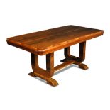 An Art Deco walnut dining table, the rounded rectangular top on two U-shaped supports and sleigh
