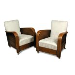 A pair of Art Deco oak framed armchairs, the reeded arms with over stuffed backs and seats, raised