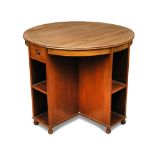 A Heal's walnut library or book table, the circular top over two fitted drawers and open shelves,