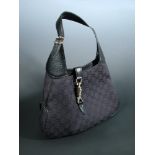 Gucci, a black canvas handbag, with stitched monogram design, black leather handle and gilt push