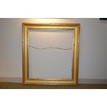 A distressed gilded wooden frame, 110 x 74 cm sight size (128 x 92 cm overall size); with a green