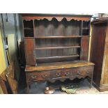 An 18th century oak dresser with raised plate rack and cupboards to the base