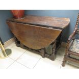 An oak gateleg table in the antique style, with fitted drawer, on spiral turned legs united by