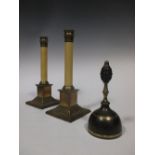 A pair of brass footed white columnar candlesticks and a handbell together with a quantity of
