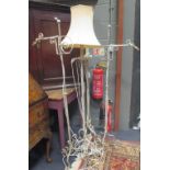 Two pairs of wrought iron standard lamps with twist stems and scroll tripod bases highest with shade