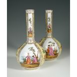 A pair of 19th century Dresden bottle bases, painted with panels of Watteauesque figures of courting