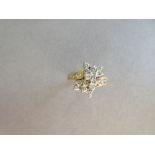 An asymmetrical diamond cluster ring, with a pierced bow form composed of tiered round brilliant cut