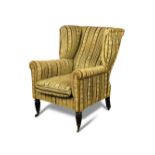 A wing back armchair in the manner of Gillow, early 19th century, with a raked back, upholstered