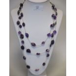 A long amethyst and silver necklace, the mixed cut cabochons all in collet mounts and interspaced