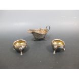 A silver sauce boat together with a pair of tub salts
