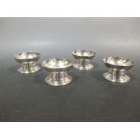 A set of four silver circular pedestal salts