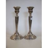 A pair of silver candlesticks (worn)