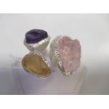 A rough cut three stone ring, the rose quartz, amethyst and citrine specimens in textured