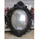 An oval mirror in carved wood frame 29cm high
