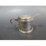 A Victorian silver drum mustard, decorated with floral swag, London 1870, with an associated spoon