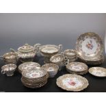 A tea service decorated with floral panels within a grey and gilt border comprising cups, saucers,