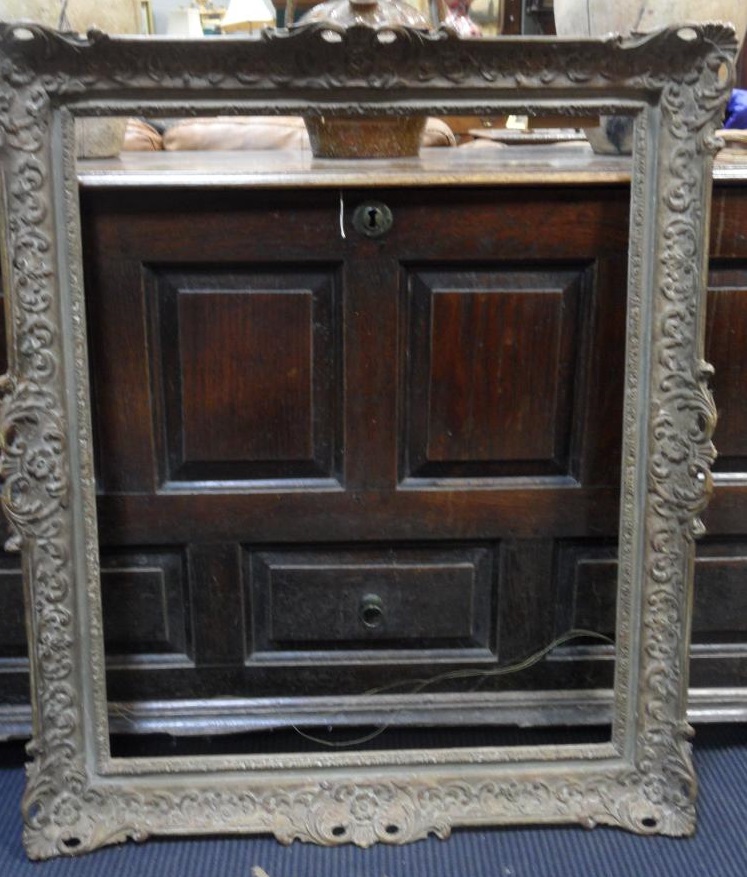 A large 20th Century gilt gesso rectangular swept frame, 77 x 63 cm sight size, an oriental red