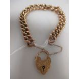 A 9ct curblink bracelet, the half textured links set to heart shaped padlock clasp with safety chain
