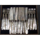 Twelve pairs of silver bladed dessert knives and forks (some damage to handles)