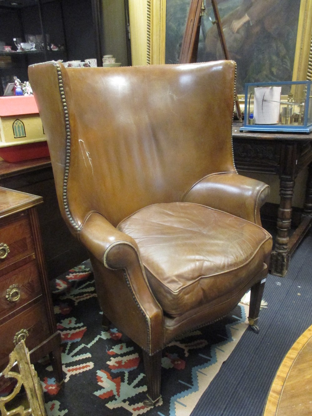 A George III style leather upholstered barrel back armchair