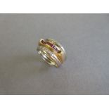 A modern ruby and diamond band ring, the central band of yellow precious metal channel set to the