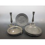 Seven 18th/19th century pewter plates, a warming dish base and a pair of candlesticks