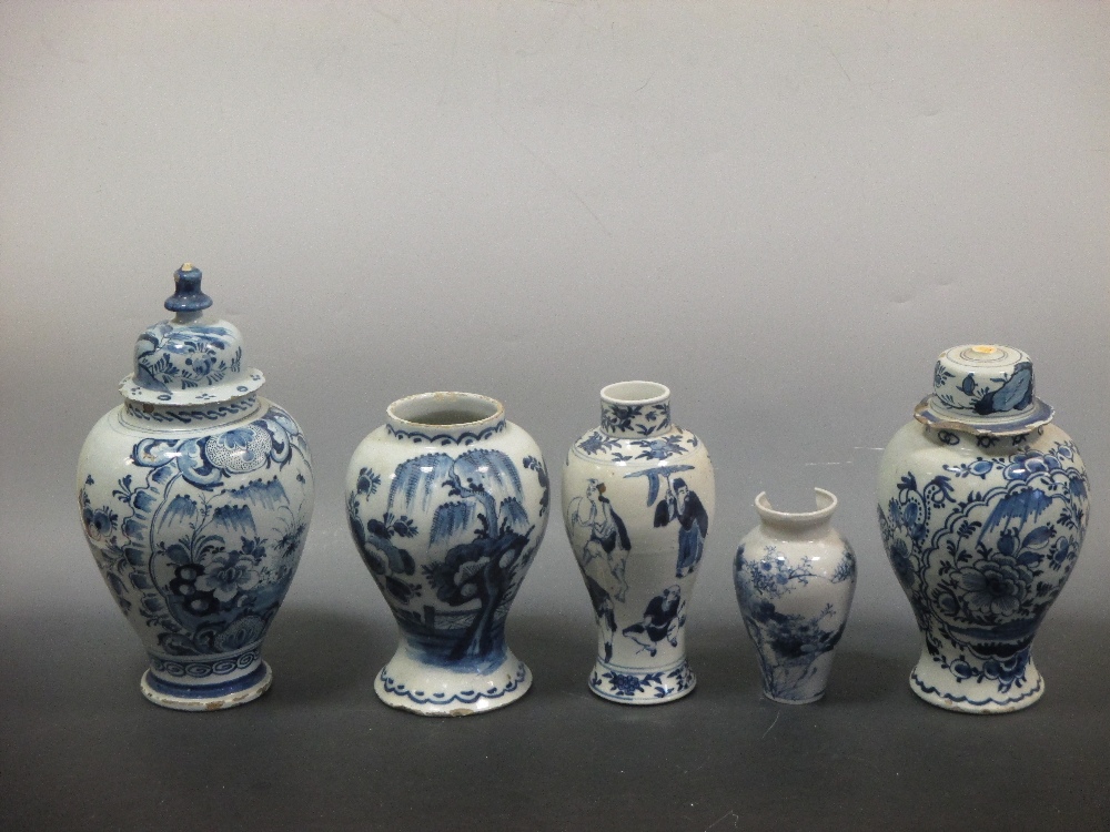 An 18th century Delft blue and white baluster vase and cover; two Delft blue and white ovoid vases