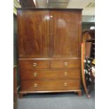 A Regency mahogany linen press, with a pair of doors enclosing sliding shelves above two short and