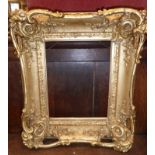 A 19th Century ornate rococo style giltwood frame decorated with floral motifs and having pierced
