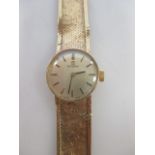 A ladies 9ct Omega wristwatch, the round champagne coloured dialt with baton numerals, set to a flat