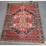 A tribal rug with red and dark blue ground, decorated with stylised flowers and boteh, 147 x 115cm