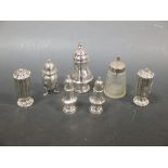 A hexagonal salt and pepper set, Indian silver; four silver sugar sifters and a silver topped