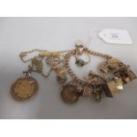 A 9ct curblink charm bracelet and a variety of charms to include an 1873 half sovereign (62g)