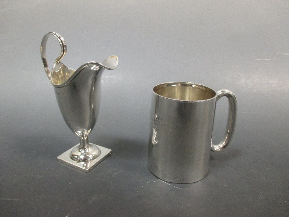 A silver helmet shaped cream jug together with a silver 'Ovaltine' half pint mug