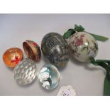 A late 19th century Russian glass egg painted with flowers, two other glass eggs, a paper egg box