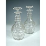 A pair of Anglo-Irish magnum decanters and stoppers, the facetted triple ringed necks above