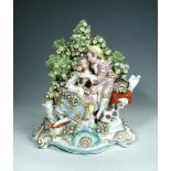 A large Samson porcelain boccage group, modelled in 18th century Derby style with young lovers in an