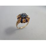 A sapphire and blue enamel ring, designed as a flowerhead with the central stamens a cluster of